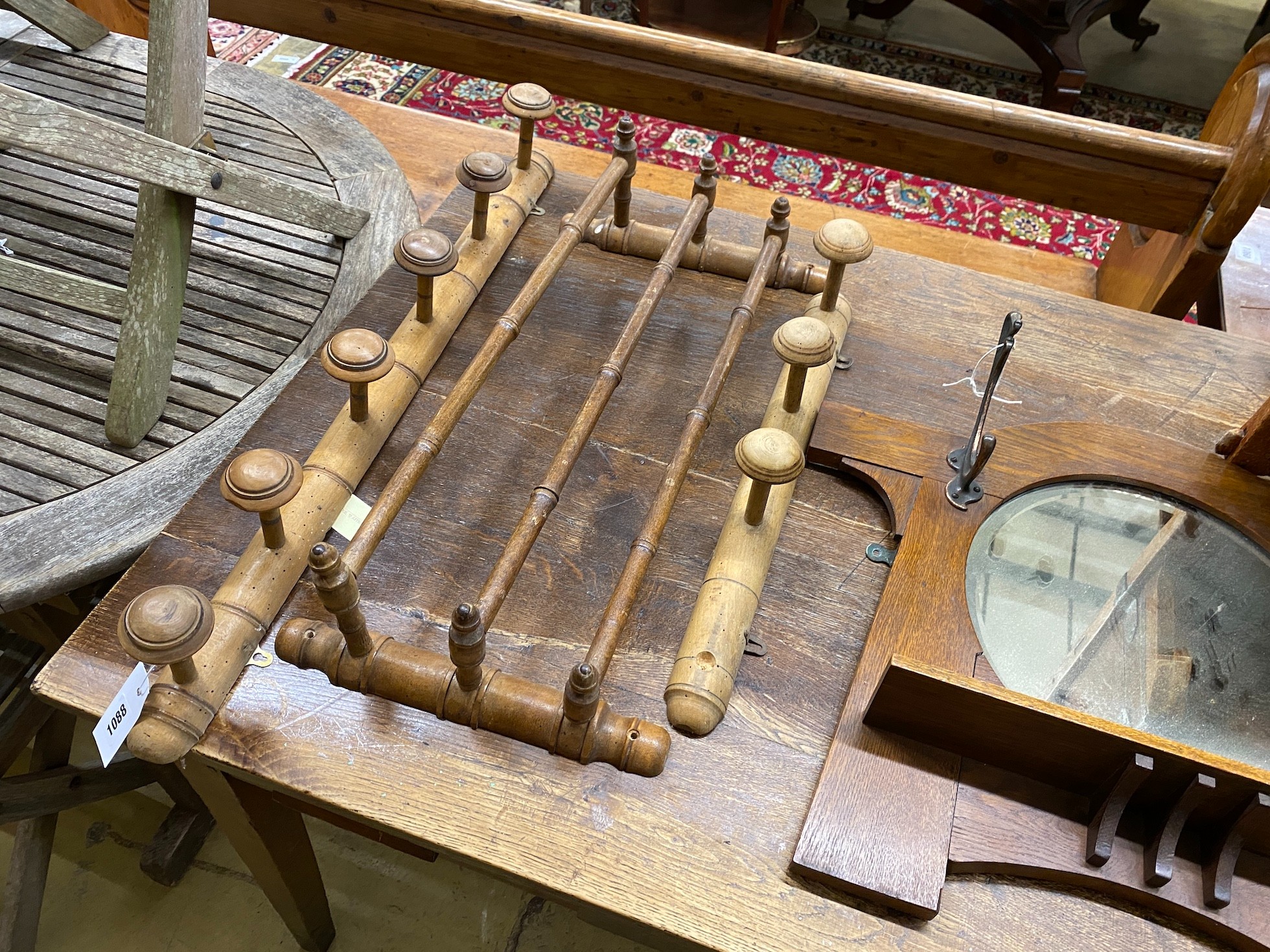 A hall mirror, two late Victorian beech coat racks, a hanging rail, two pairs of bellows, and a cheese carrier